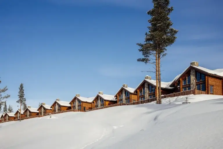 Rad av lodger med snötäckta tak i Idre Bergsby